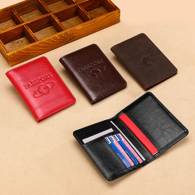 Four leather passport holders in different colors on a beige surface with an open black wallet.